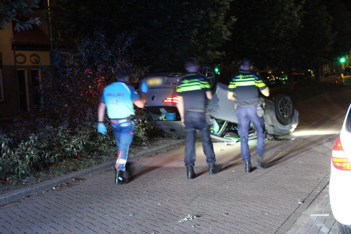 Auto slaat over de kop na botsing tegen stilstaande auto's