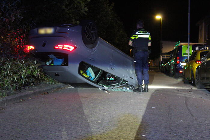 Auto slaat over de kop na botsing tegen stilstaande auto's