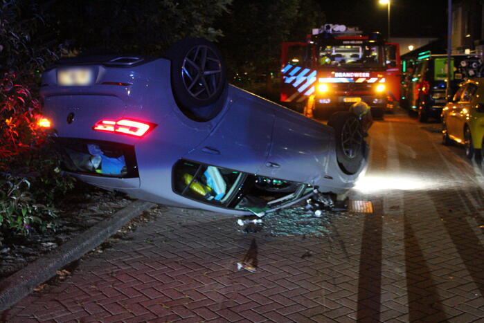 Auto slaat over de kop na botsing tegen stilstaande auto's