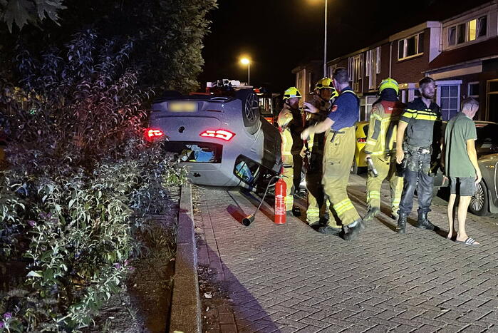 Auto slaat over de kop na botsing tegen stilstaande auto's