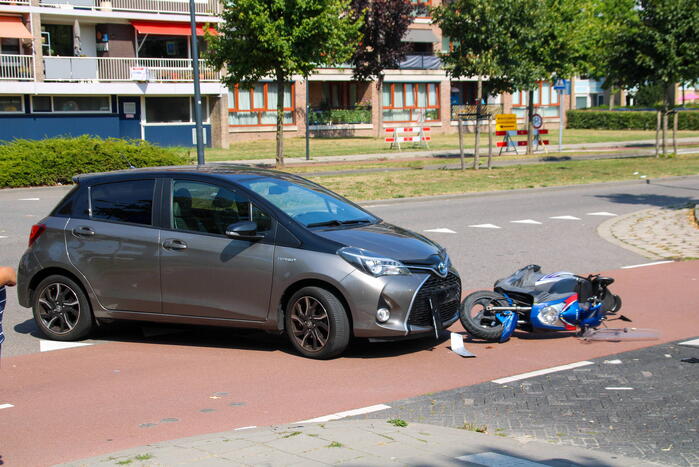 Afslaande automobilist ziet scooterrijder over het hoofd