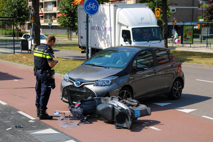 Afslaande automobilist ziet scooterrijder over het hoofd