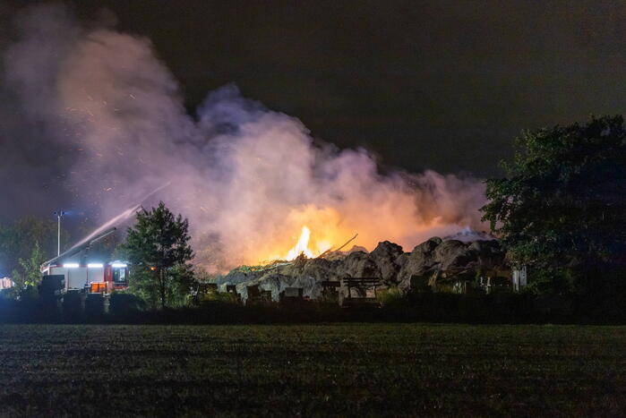 Flinke buitenbrand in grote stapel hooi