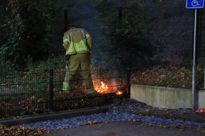 Bladeren vliegen in brand op parkeerterrein