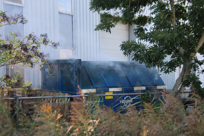 Afvalcontainer met hout in brand