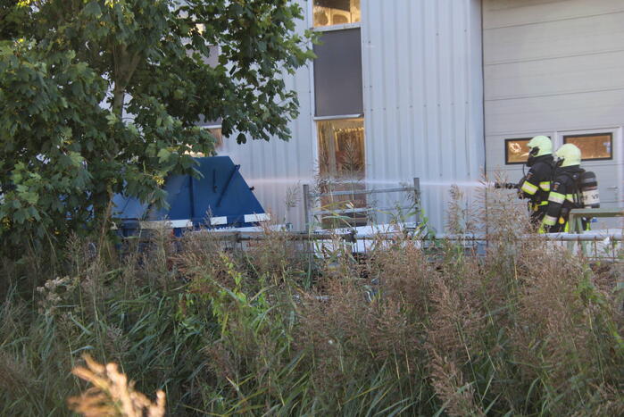 Afvalcontainer met hout in brand