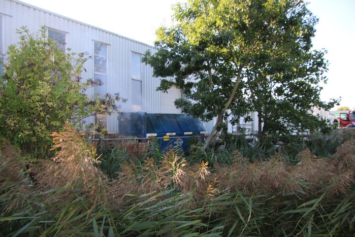 Afvalcontainer met hout in brand