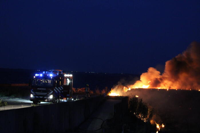 Groot stuk dijk in brand