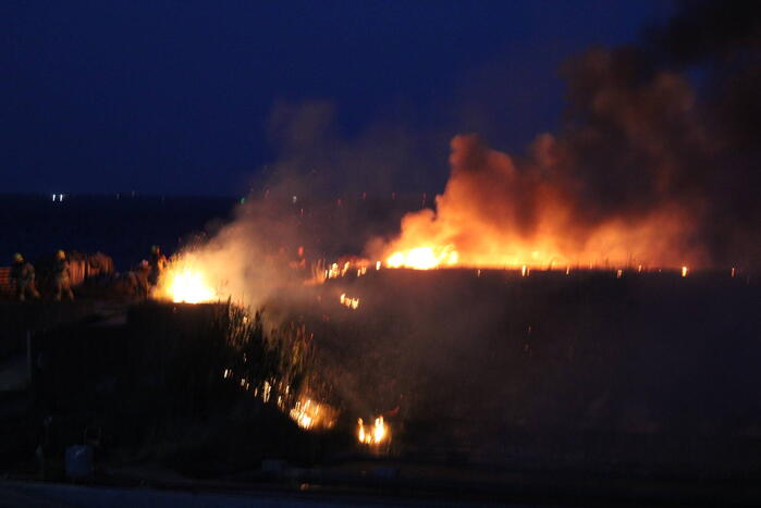 Groot stuk dijk in brand