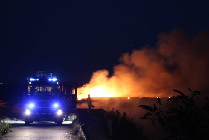 Groot stuk dijk in brand