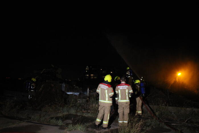 Groot stuk dijk in brand