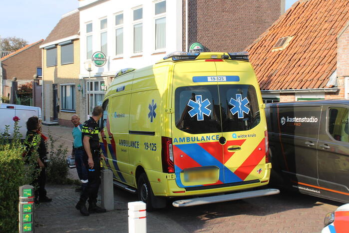 Persoon komt onder bestelbus terecht