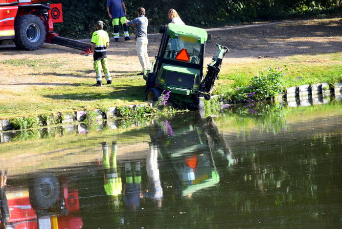 Grasmaaier dreigt in het water te vallen