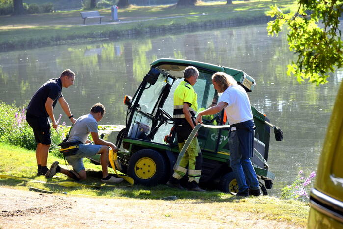 Grasmaaier dreigt in het water te vallen
