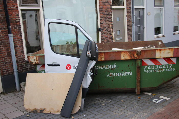 Pakketbezorger botst tegen bouwcontainer en knalt tegen woning