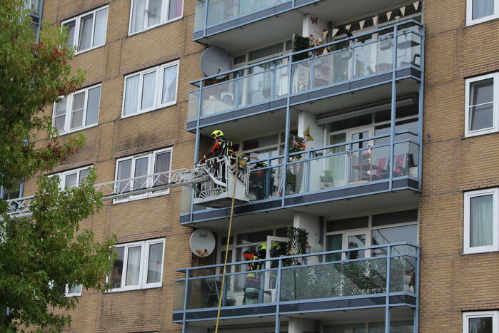 Brandweer blust brand op balkon van flat