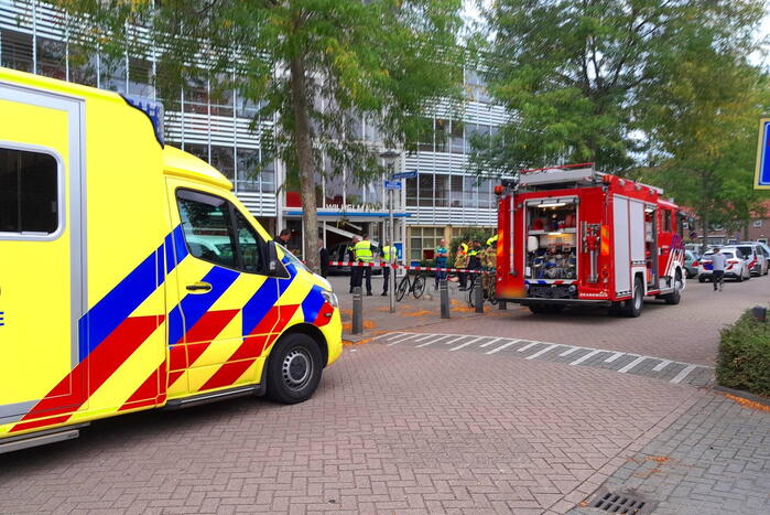 Bestuurster ramt met auto entree flatgebouw