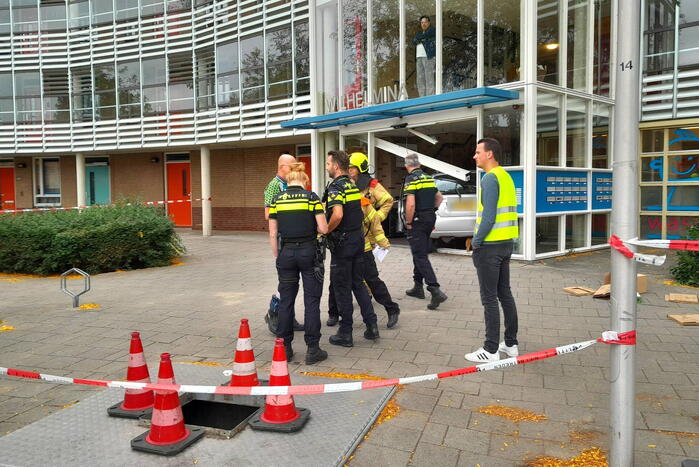 Bestuurster ramt met auto entree flatgebouw