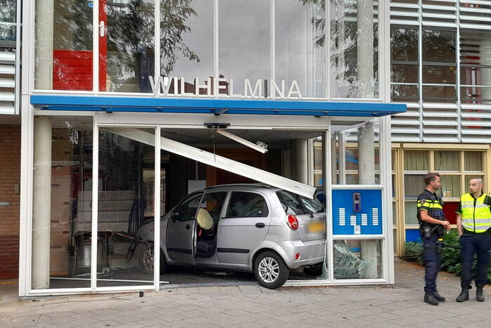 Bestuurster ramt met auto entree flatgebouw