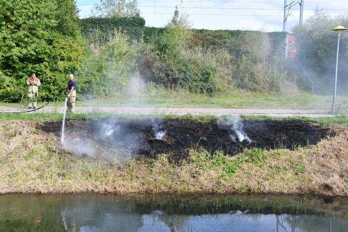 Man helpt brand blussen met emmers water