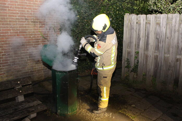 Brandweer blust brand in prullenbak