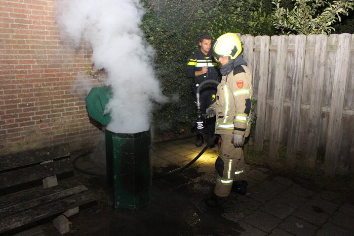 Brandweer blust brand in prullenbak