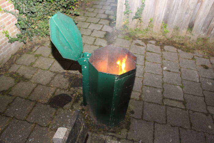 Brandweer blust brand in prullenbak