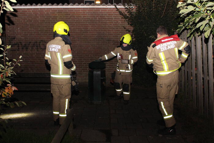 Brandweer blust brand in prullenbak