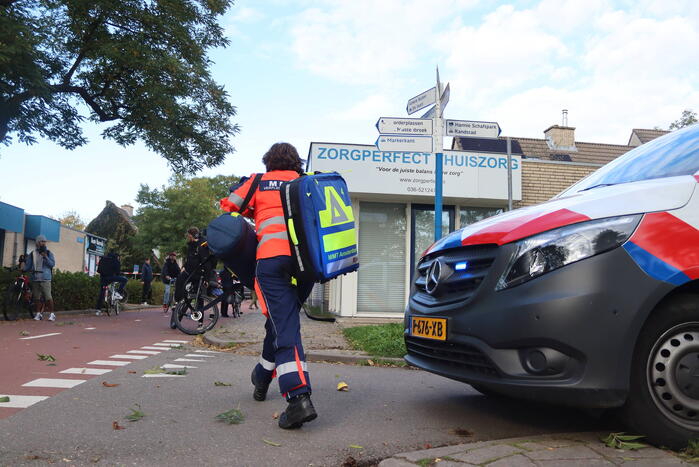 Persoon belandt onder bestelbus