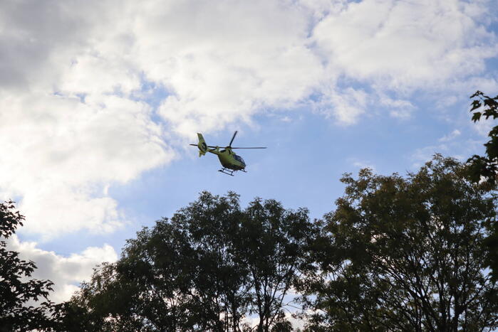 Persoon belandt onder bestelbus