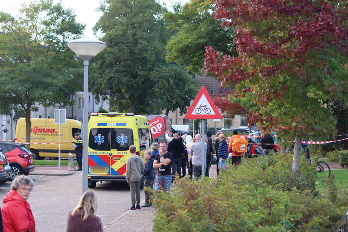 Persoon belandt onder bestelbus