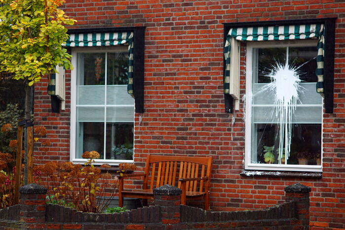 Verfbom tegen raam gegooid