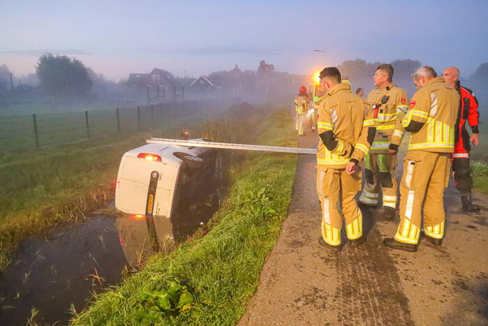 Bestelbus belandt op zijn kant in sloot
