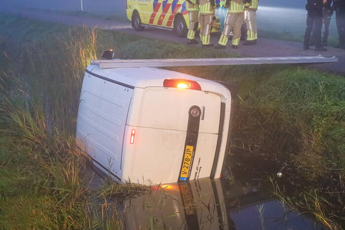 Bestelbus belandt op zijn kant in sloot