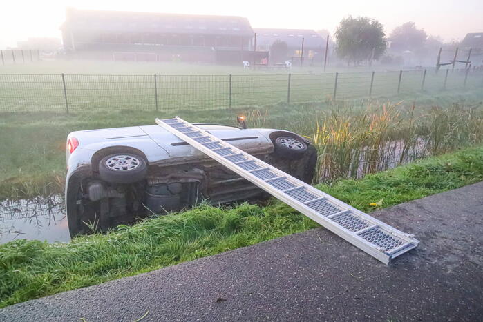 Bestelbus belandt op zijn kant in sloot