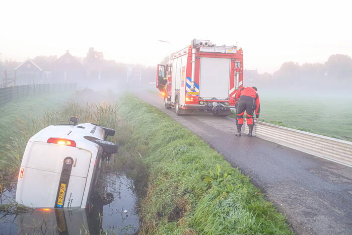 Bestelbus belandt op zijn kant in sloot