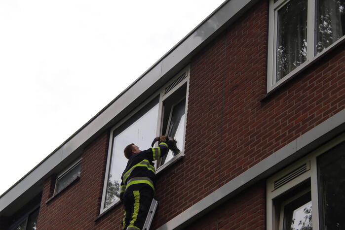 Kat bekneld tussen klapraam van woning
