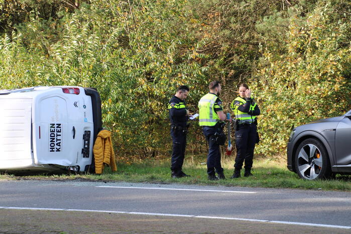 Bestelbus op zijn kant na ongeval