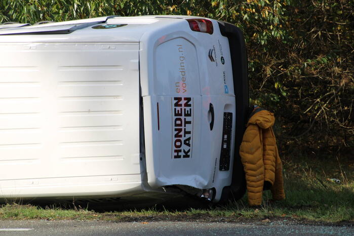 Bestelbus op zijn kant na ongeval