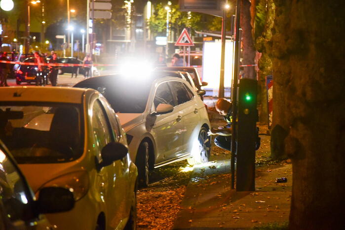 Persoon lost schoten op auto