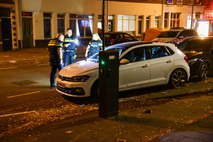 Persoon lost schoten op auto