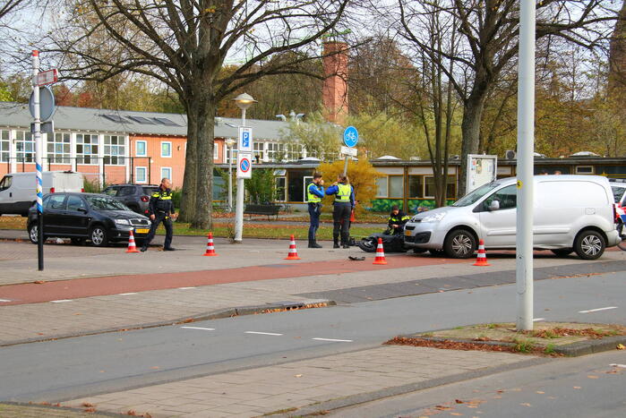 Afslaande bestelbus ziet scooterrijder over het hoofd