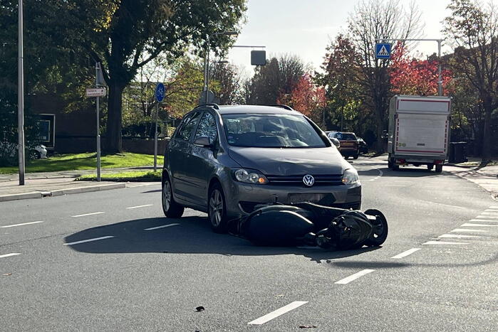 Personenauto ziet scooterrijder over het hoofd