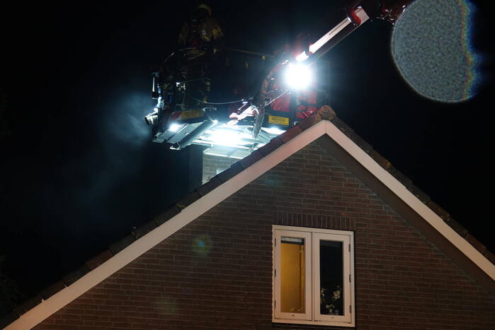Brandweer blust brand in schoorsteen