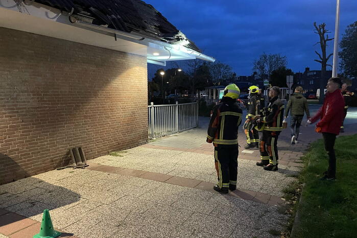 Vrachtwagen rijdt tegen dak van gebouw