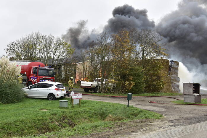 Grote stapel hooi vliegt in brand