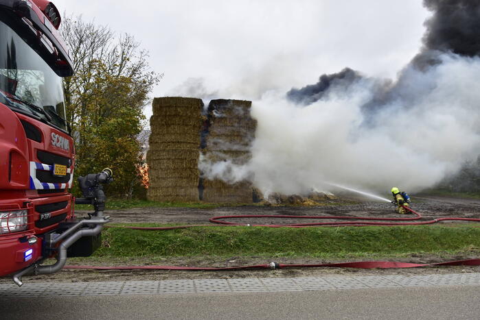 Grote stapel hooi vliegt in brand