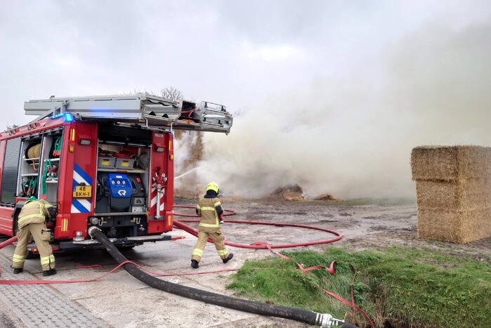 Grote stapel hooi vliegt in brand