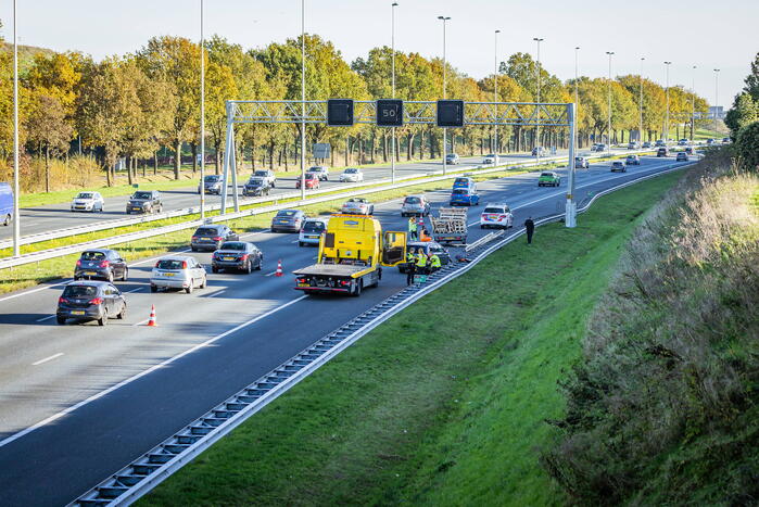 Automobilist verliest overbeladen aanhangwagen met pallets en crasht
