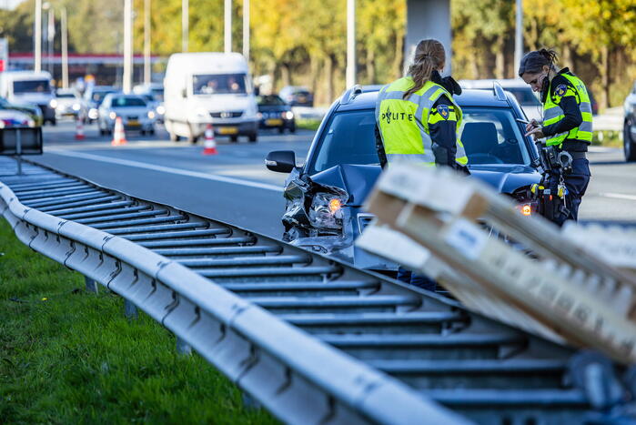 Automobilist verliest overbeladen aanhangwagen met pallets en crasht